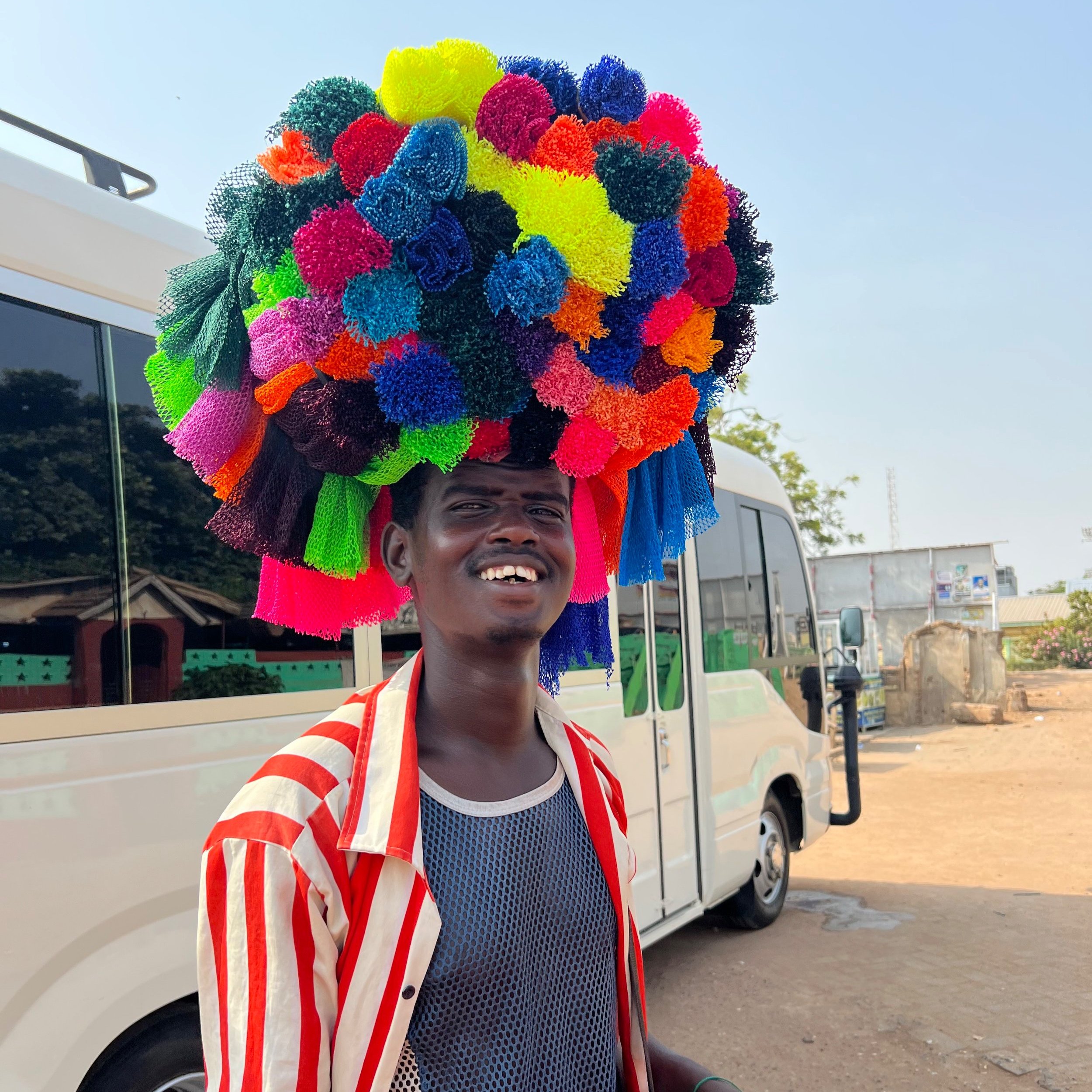 Vendor with colorful wash sponges on his head at the Kwame Nkrumah Memorial Park In Accra, Ghana